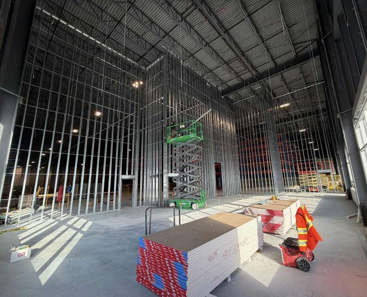 High-wall steel framing erected from a scissor lift in a distribution facility