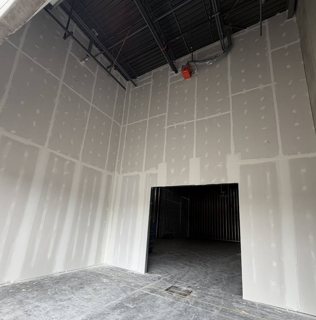 Level 4 taping and finishing on tall drywall walls with a framed opening