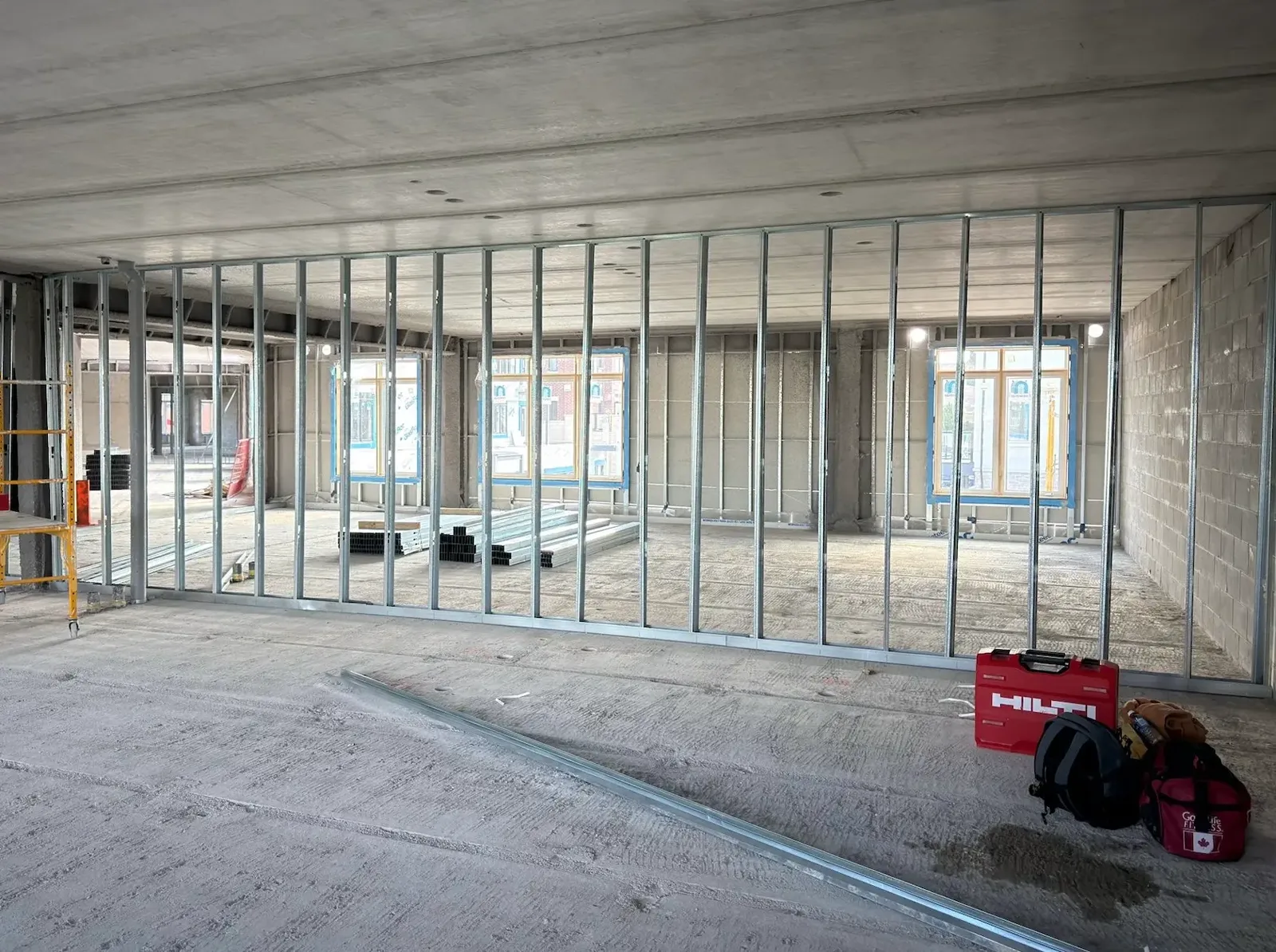 Steel stud partition wall framed along a window line in a commercial interior