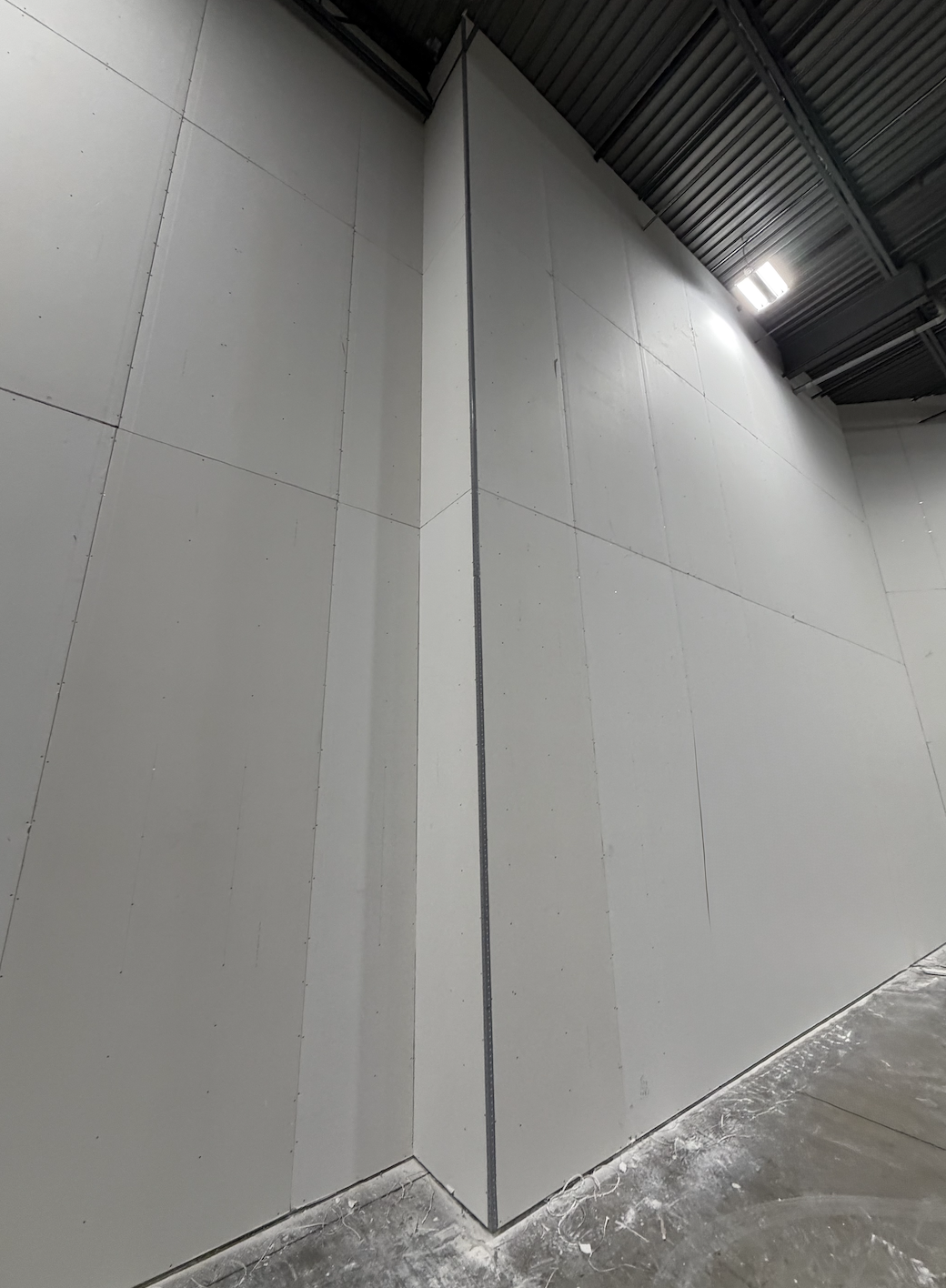 Finished full-height drywall partition in a warehouse interior